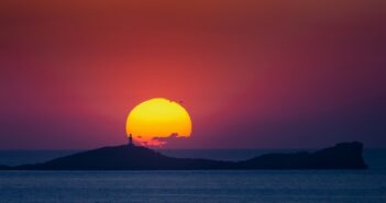 Wenn wir unser Glückshotel Ibiza buchen, dann hoffen wir auf ein Hotel nahe einem romantischen Ort wie hier an der Cala Conta mit einem Sonnenuntergang, vor dem sich die Silhouette der Insel Na Plana erhebt.